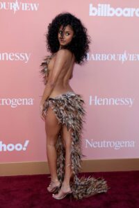 "Tyla Stuns in Daring Feather Ensemble, Showcasing Her Flawless Figure at Billboard Women in Music Event" 1