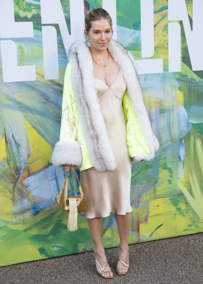 Sienna Miller Flaunts Her Voluptuous Boobs in a Sultry Fur and Silk Ensemble that Exposes Her Sexy Cleavage to the Fullest