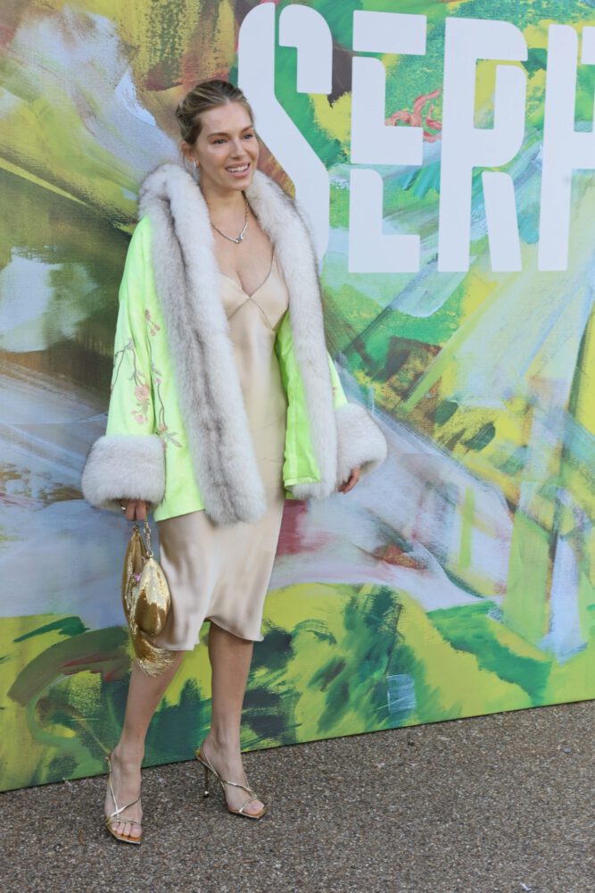 Sienna Miller Flaunts Her Voluptuous Boobs in a Sultry Fur and Silk Ensemble that Exposes Her Sexy Cleavage to the Fullest
